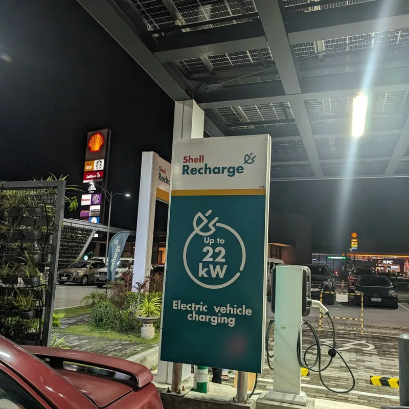 Shell Recharge pricing sign showing 22kW speed at 28 pesos per kWh at night in the Philippines