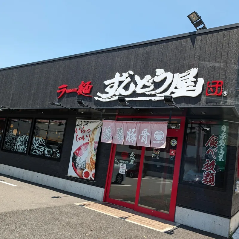 Exterior of Zundo-Ya ramen restaurant with black facade and red entrance in Kyoto, Japan.