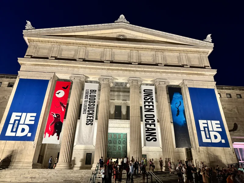 Field Museum in Chicago, Illinois exterior at night with illuminated grand columns and event banners for Blood Suckers and Unseen Oceans exhibits