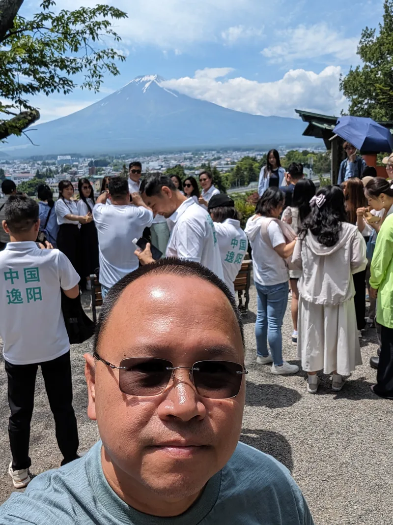 Family of four posing in front of Mount Fuji overlooking Fujiyoshida, Yamanashi, Japan.