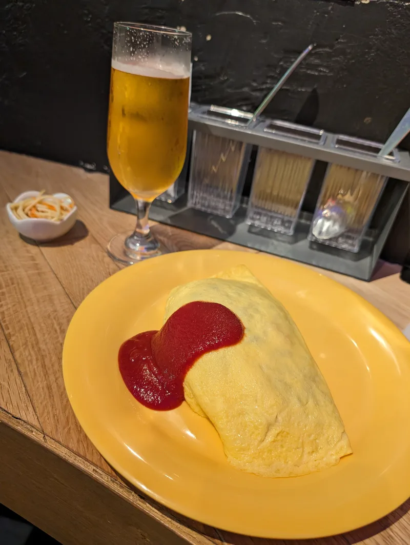 Japanese omurice with a heart drawn in ketchup next to a beer, Tokyo, Japan.