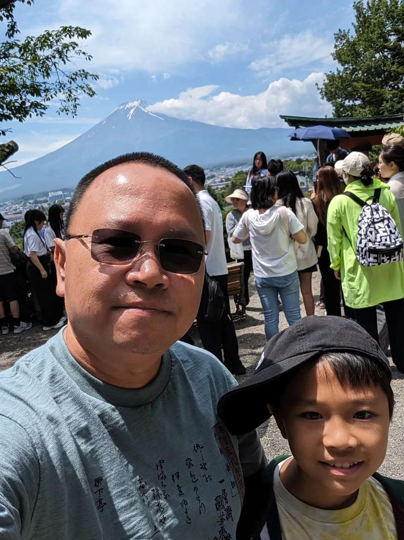 Selfie of man and son with Mount Fuji in background at Arakurayama Sengen Park, Yamanashi, Japan.