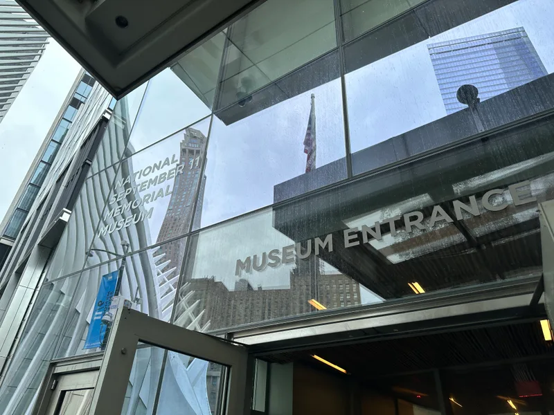 The 9/11 Memorial Museum entrance Glass entrance of National September 11 Memorial Museum reflecting buildings