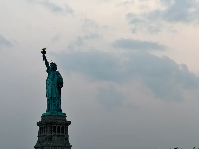 Lady Liberty up close at sunset Close-up of Statue of Liberty with green patina and torch against sunset sky
