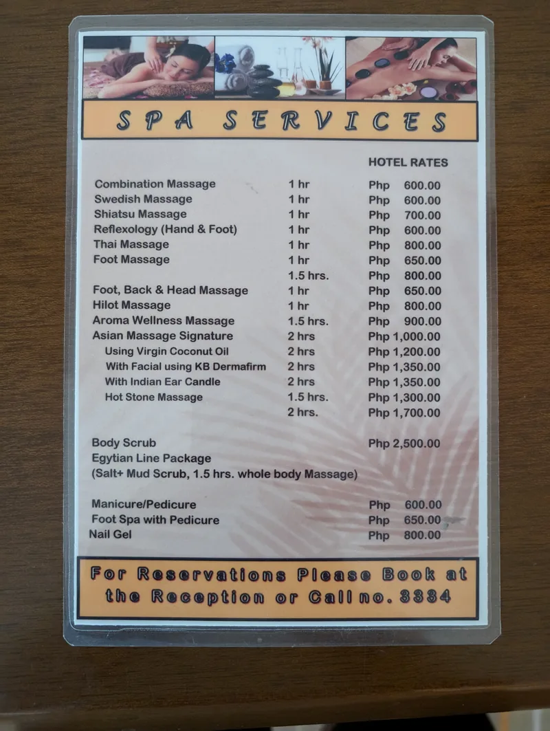 Laminated spa services menu showing massage and beauty treatment prices in Philippine Pesos at a hotel in Puerto Princesa Palawan