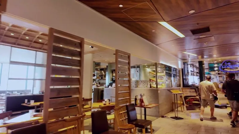 Interior of the 13th floor restaurant area at Shibuya Sky, Shibuya, Tokyo, Japan, with modern wooden accents, warm lighting, and large windows.