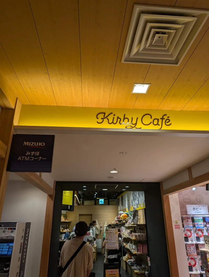 Entrance to the Kirby Cafe with a distinctive yellow sign and wooden ceiling at Solamachi, Tokyo, Japan.