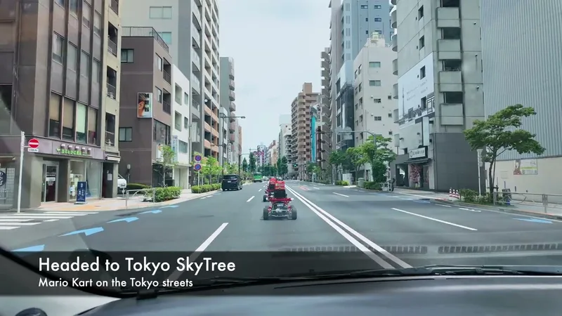View from car of a Tokyo city street with go-karts from a Mario Kart street experience, buildings and blue road arrows visible.
