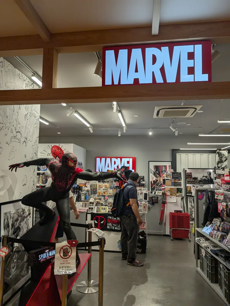 Life-sized Spider-Man Miles Morales statue inside a Marvel store with the MARVEL logo illuminated above, Solamachi, Tokyo, Japan.