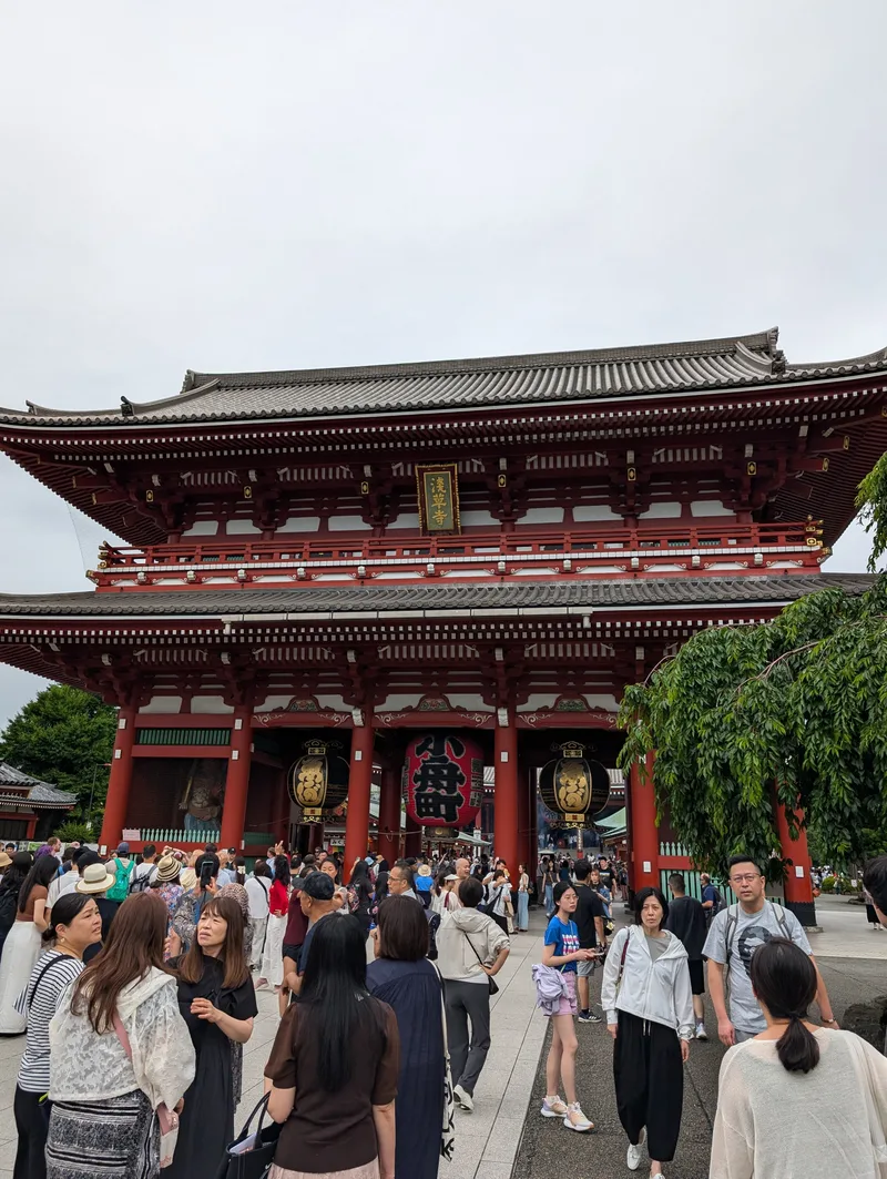 Crowds gathered in front of the red Hozomon Gate at Senso-ji Temple with its iconic giant red lantern, Asakusa, Tokyo, Japan.