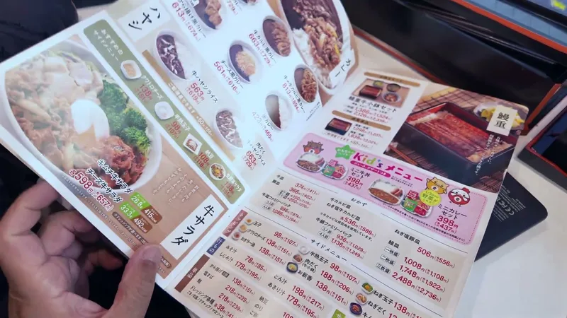 Japanese menu with rice bowls, salads, and kid's meals at Yoshinoya restaurant in Shibuya, Tokyo, Japan