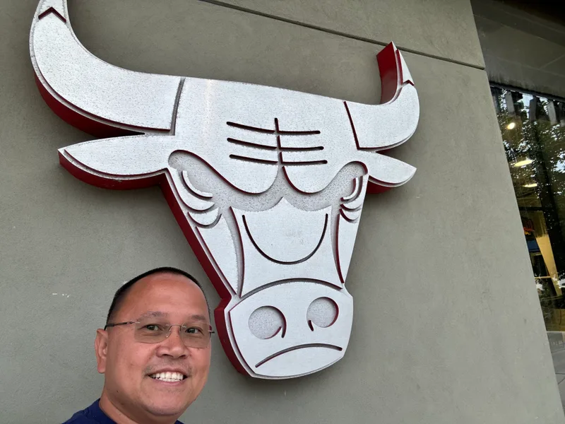 Man smiling in close-up selfie with Chicago Bulls logo at the Madhouse Team Store, United Center, Chicago, Illinois
