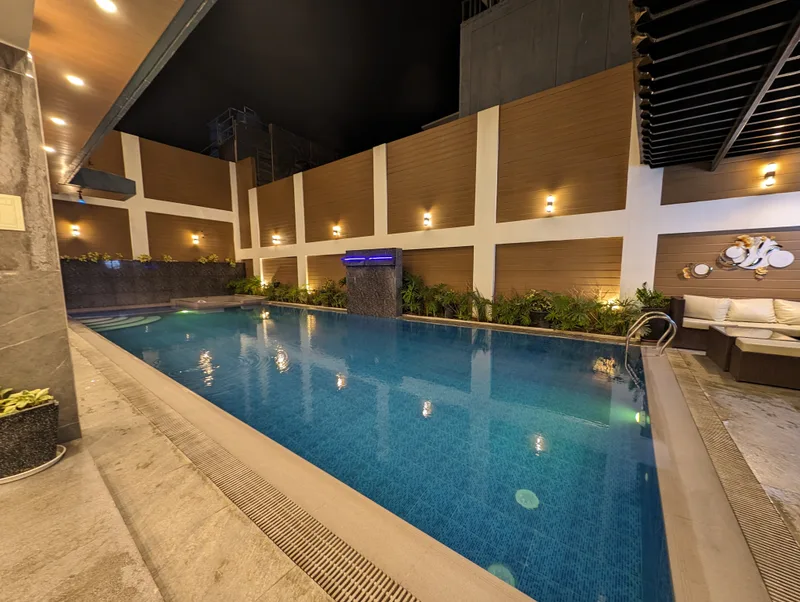 Hotel swimming pool at Avery Ridge Resort in Pansol, Calamba, Laguna at night with warm lighting and blue waterfall feature.